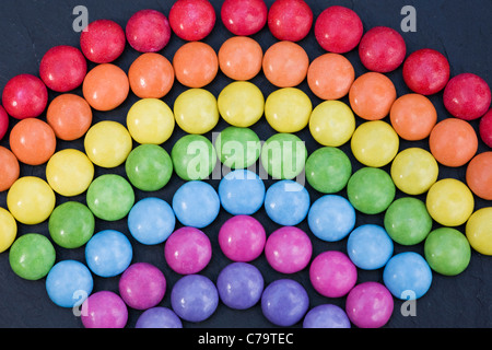 Rainbow smartie pattern on black background. Close up Stock Photo