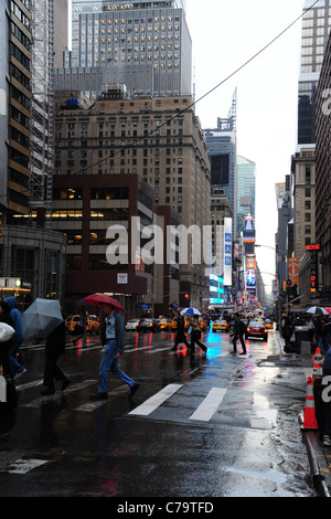 Rain portrait 7th Avenue, umbrella people, multi-lane cars, wet tarmac neon reflections, towards Times Square, New York City Stock Photo