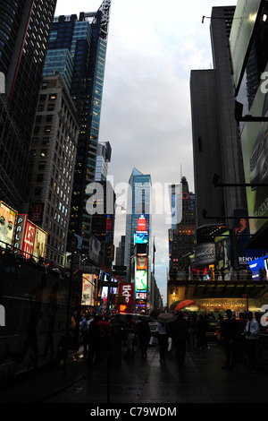 Evening twilight portrait Times Square neon skyscrapers, tour bus, pedestrians TKTS theater booth, 7th Avenue, New York City Stock Photo