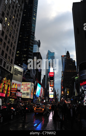 Evening twilight portrait blue red rainy tarmac traffic neon skyscrapers theatres, 7th Avenue, Times Square, New York City Stock Photo