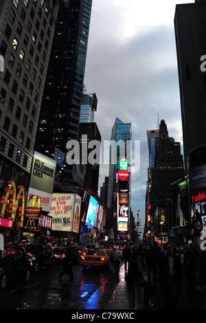 Evening portrait blue red pink rainy tarmac 7th Avenue, traffic, pedestrians, neon skyscrapers, Times Square, New York City, USA Stock Photo