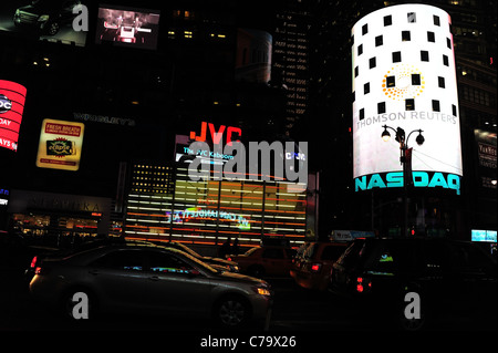 Night shot, across road from Hard Rock Cafe, cars moving past neon JVC NASDAQ billboards, 7th Avenue, Times Square, New York Stock Photo