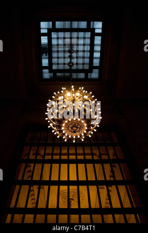 A large hanging chandelier inside the New York Grand Central Terminal train station. Stock Photo