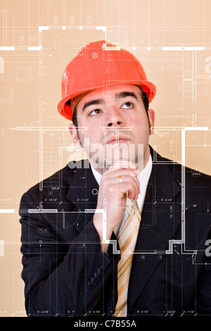 A custom home builder or architect thinks as he examines the blueprints on the clear glass display in front of him. Stock Photo