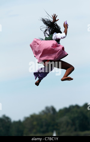 Woman in traditional bavarian dress jumping through the air into Lake Chiemsee Upper Bavaria Germany Stock Photo