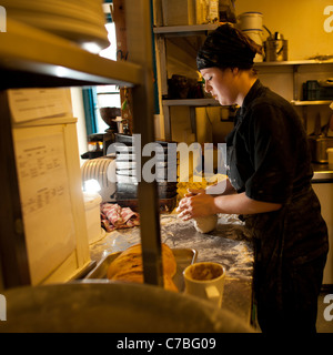A woman making bread rolls at The Treehouse organic vegetarian cafe restaurant, Aberystwyth Wales UK Stock Photo