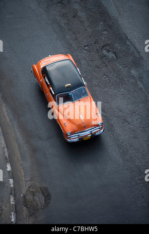 Orange vintage American car taxi on Malecon sea wall, City of Havana, Havana, Cuba Stock Photo