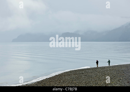 Two fishermen fishing for salmon in Resurrection Bay along Lowell Point in morning fog in Seward, Alaska. Stock Photo