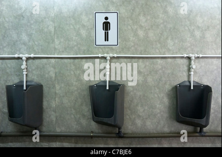 Row of urinals in a public restroom Stock Photo