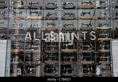 The main window, full of old fashioned sewing machines, of the All Saints store on Market Street, Manchester, UK. Stock Photo