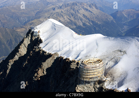 AERIAL VIEW. Aiguille du Gouter (alt.: 3863m). France's highest mountain hut. Next to the old hut, a new, larger one is being built. Saint-Gervais. Stock Photo