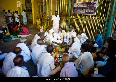 Hindu pilgrims have lunch in the Meenakshi Amman temple in Madurai, Tamil Nadu, India. Stock Photo