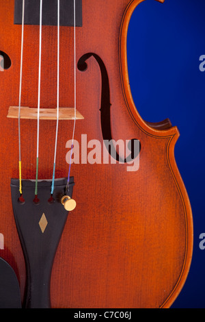 A professional violin viola isolated against a blue background in the vertical format. Stock Photo