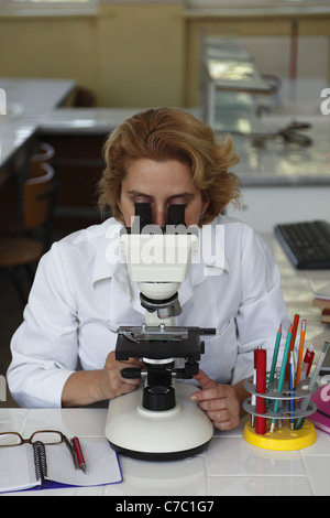 Female researcher looking through microscope in a laboratory. Stock Photo