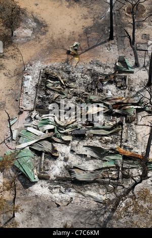 Aerial of a collapsed metal building destroyed by wildfire  that burned through a heavily forested area near Bastrop Texas Stock Photo