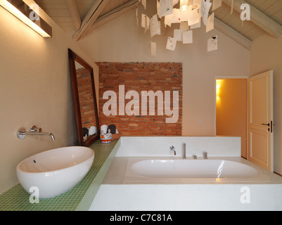 modern bathroom in the attic with wood ceiling and brick wall Stock Photo