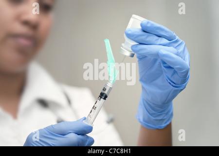 Syringe preparation by a female doctor or certified registered nurse anesthetist practicing safety medical procedures Stock Photo
