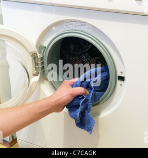 Caucasian Adult Male Loading or Unloading an Electric Bosch Washing Machine, UK MODEL RELEASED Stock Photo
