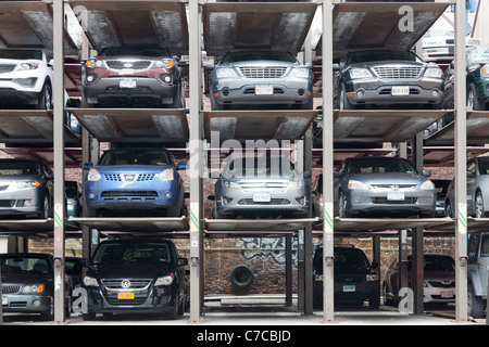 Cars parked in vertical hydraulic parking spaces in a parking lot in New York City. Stock Photo