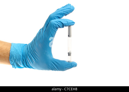 A gloved hand holding a syringe between two fingers Stock Photo