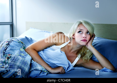 Young sleepless woman laying in bed with insomnia Stock Photo