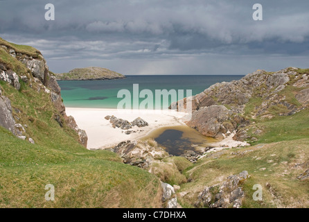 Isolated sandy beach at Achmelvich Bay as dark storm clouds approach from the western horizon Stock Photo