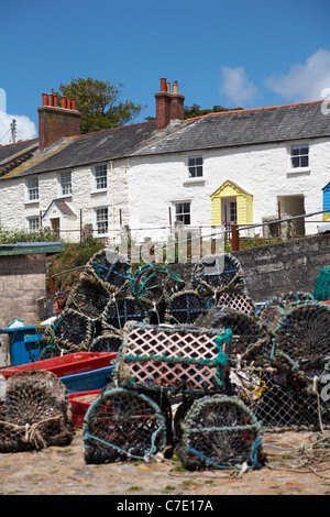 Cottages at Charlestown with lobster pots and crates in the foreground, St Austell, Cornwall in May Stock Photo