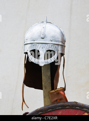 Steel helmet hanging on a wooden pole against a white tent of warriors camp Stock Photo