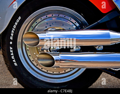 Rear wheel and shiny exhaust pipes of an immaculate Harley Davidson motorcycle Stock Photo