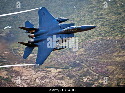 USAF F-15E Strike Eagle makes a turn during a low flying flight in mid Wales shot from the hill side