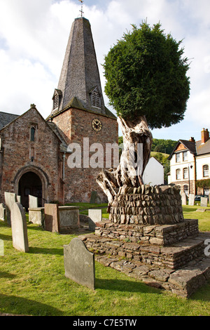 Ancient and revered yew tree in the churchyard of short steepled St Dubricius parish church in Porlock Somerset UK Stock Photo