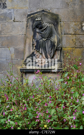 Memorial with the figure of a woman in mourning in an overgrown section of Warriston Cemetery in Edinburgh, Scotland. Stock Photo