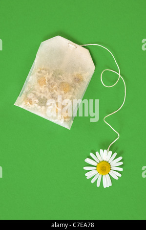 Bag of chamomile tea over green background - concept Stock Photo