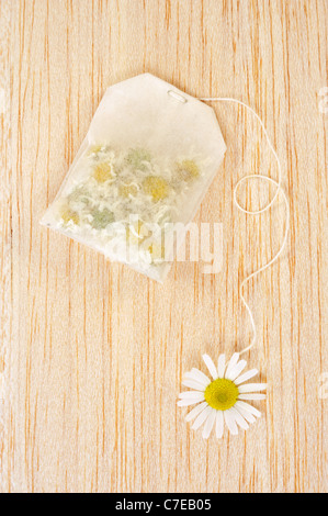 Bag of chamomile tea over wooden background - concept Stock Photo