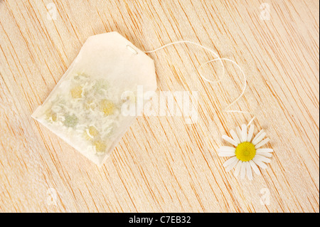 Bag of chamomile tea over wooden background - concept Stock Photo
