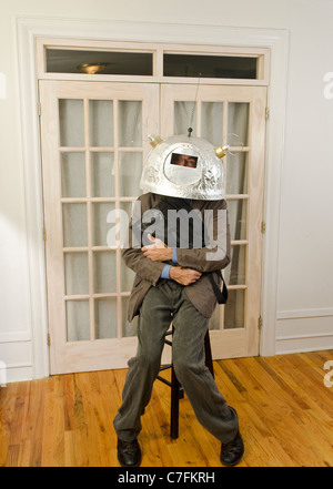 man clutching briefcase wearing helmet with antennas Stock Photo