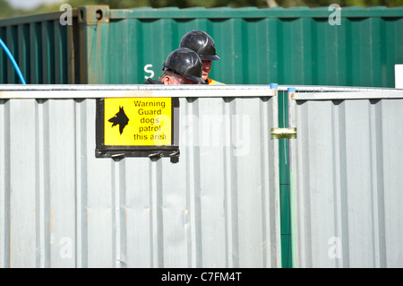 Bailiffs looking over the fence of compound prior to the eviction of travellers at Dale Farm, Basildon,Essex. Photo:Simon Ford Stock Photo
