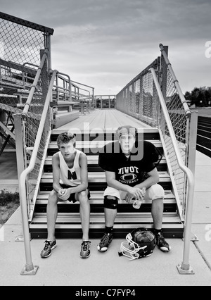Twin teenage boys resting after school sports practice Stock Photo