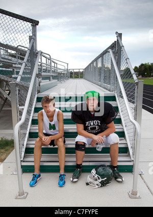 Twin teenage boys resting after school sports practice Stock Photo
