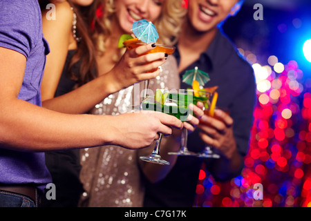 Close-up of several cocktails in hands of young people having party Stock Photo