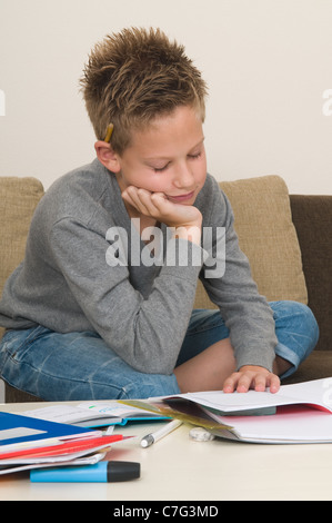 This boy is very tired of doing his homework, he fell asleep Stock Photo