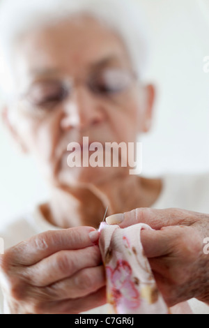 Detail of a senior woman stitching fabric Stock Photo