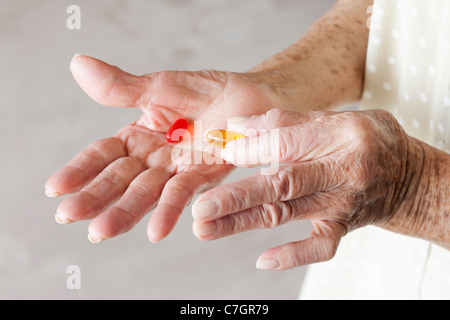 Detail of capsules in the hands of a senior woman Stock Photo