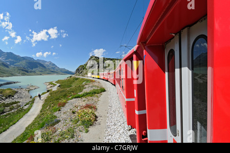 Train ride with Rhätische Bahn on the Bernina line from Ospizio Bernina to Poschiavo passing the Lago Bianco. Switzerland. Stock Photo