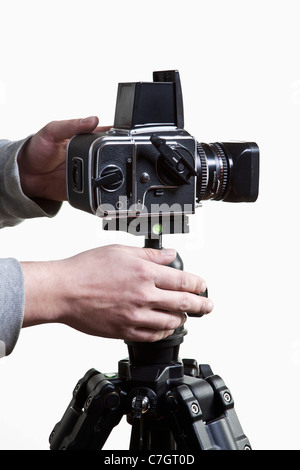 A photographer adjusting a medium format camera on a tripod, close-up of hands Stock Photo