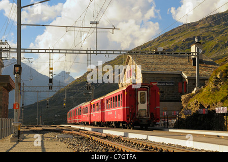 Train of Rhätische Bahn at Ospizio Bernina railway station on the Berninapass. Switzerland, Western Europe, Graubünden, Bernina. Stock Photo
