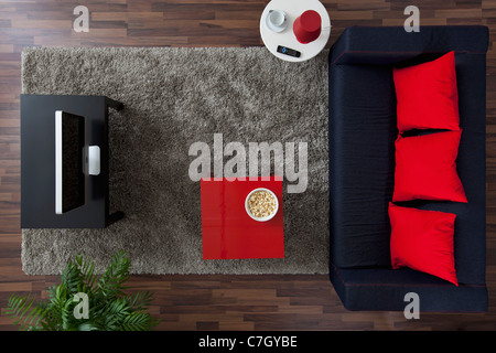 A sofa, TV and side table with a bowl of popcorn, overhead view Stock Photo