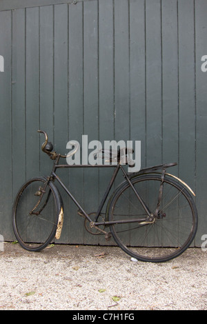 An old bicycle leaning against a wall Stock Photo