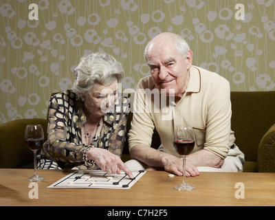Senior man grimaces as senior woman contemplates a move playing muehle Stock Photo