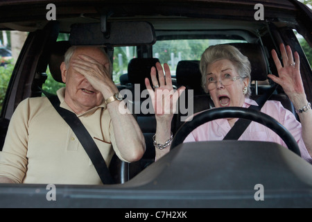 Senior woman having trouble learning to drive as man in passenger seat despairs Stock Photo